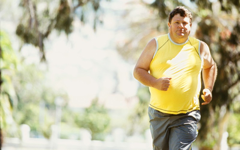 portrait of a mid adult man jogging in a park --- Image by © Ro